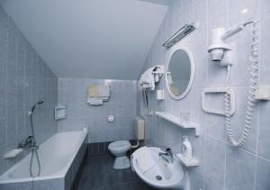 a bathroom with a sink toilet and a mirror at Apartments & Rooms Peranic in Novalja