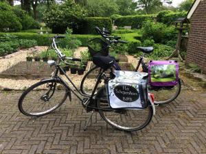 a bike with a bag on it parked on a sidewalk at Het Schepershoes in Peest
