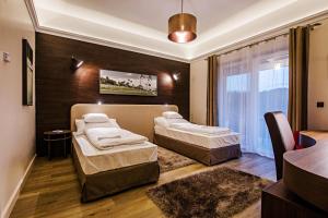 a hotel room with two beds and a table at Pannónia Golf & Country Club in Alcsútdoboz