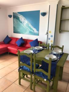 a dining room with a table and a red couch at Casa bella vista mare in Corralejo