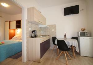 cocina y dormitorio con cama, mesa y sillas. en Apartment Noemi in city center, en Poreč