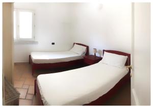 Pokój z 2 łóżkami i oknem w obiekcie Incanto Apartment Golfo Aranci w mieście Golfo Aranci