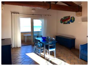 jadalnia z niebieskim stołem i widokiem na ocean w obiekcie Incanto Apartment Golfo Aranci w mieście Golfo Aranci