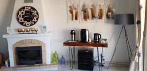 a living room with a fireplace and a clock on the wall at Quinta Nova Vale Del Rey in Carvoeiro