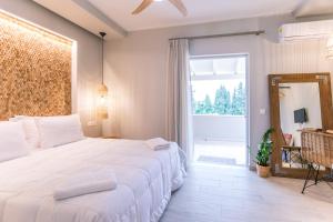 a bedroom with a large bed and a large window at Rarakos Houses Corfu in Corfu Town