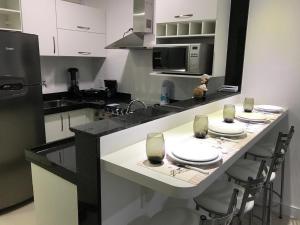 a kitchen with a table with plates and glasses on it at Pedaço do Paraíso em Arraial do Cabo in Arraial do Cabo