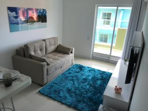 a living room with a couch and a blue rug at Pedaço do Paraíso em Arraial do Cabo in Arraial do Cabo
