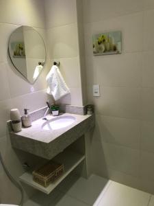 a bathroom with a sink and a mirror at Pedaço do Paraíso em Arraial do Cabo in Arraial do Cabo
