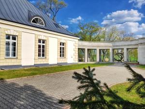 a large white house with a brick driveway at Pałac w Krzelowie in Krzelów