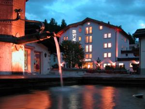 uma fonte de água em frente a um edifício em Hotel Post Sils Maria em Sils Maria