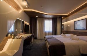 um quarto de hotel com duas camas e uma televisão em Garni Hotel Boutique 25h em Niš