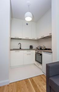 een keuken met witte kasten en een wastafel bij CR Kameralny Apartament przy Pałacu Branickich in Białystok