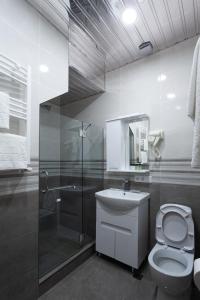 a bathroom with a toilet and a shower and a sink at Hotel Avenue 106 in Tbilisi City