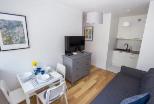 a small living room with a table and a kitchen at CR Kameralny Apartament przy Pałacu Branickich in Białystok