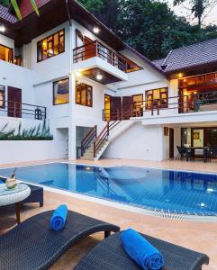 a house with a swimming pool in front of a house at Patong Hill Estate 6 in Patong Beach