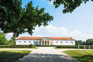 a large white building with a red roof at Pannónia Golf & Country Club in Alcsútdoboz +18 photos