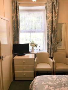 a bedroom with a desk with a computer and a window at Elerkey Guest House in Veryan