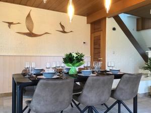 ein Esszimmer mit einem Tisch mit Stühlen und Vögeln an der Wand in der Unterkunft la maison du docteur in Heuvelland + 11 Fotos