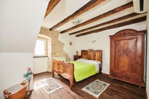 a bedroom with a bed and a wooden cabinet at App Lidia in Grožnjan