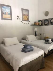 2 letti con asciugamani sopra in una stanza di Appartement Vue Mer Benerville-sur-mer a Bénerville-sur-Mer