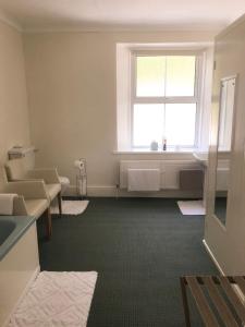 a waiting room with a window and a bath tub at Elerkey Guest House in Veryan