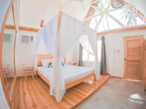 a bedroom with a bed with a mosquito net at Bermuda Triangle Bungalows in Siquijor