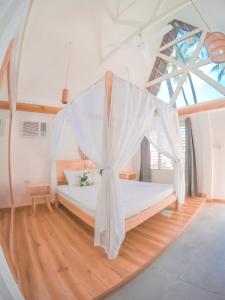 een slaapkamer met een bed met een klamboe bij Bermuda Triangle Bungalows in Siquijor