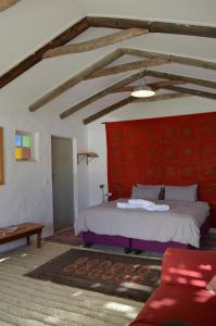 a bedroom with a bed and a red wall at Laughing Waters Farm in Stanford