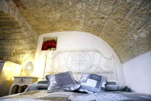 una camera da letto con un letto con cuscini sopra di La Casina Petra a Ostuni