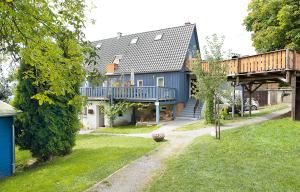 a blue house with a balcony and a yard at Bergoase Panorama-Apartments in Kirnitzschtal