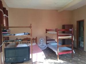 1 Schlafzimmer mit 2 Etagenbetten und einem Flachbild-TV in der Unterkunft Suíte ampla com cozinha Ibitipoca in Conceição da Ibitipoca