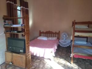 ein Schlafzimmer mit zwei Etagenbetten und einem Fernseher in der Unterkunft Suíte ampla com cozinha Ibitipoca in Conceição da Ibitipoca + 8 Fotos