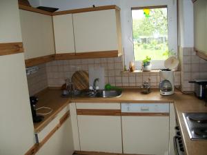 a kitchen with white cabinets and a sink and a window at Manfred Aepkers in Borgentreich