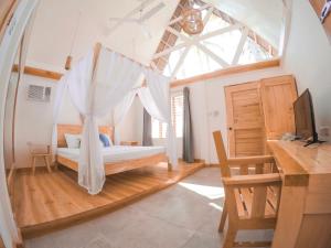 a bedroom with a bed with a window and a desk at Bermuda Triangle Bungalows in Siquijor +22 photos