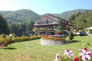 une grande maison avec des fleurs devant elle dans l'établissement hotel lo sciatore, à Cotronei