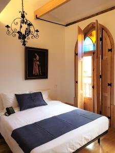 a bedroom with a large bed and a chandelier at Casa da Baixa Downtown House in Coimbra