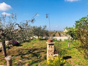 un pilastro di mattoni nel mezzo di un giardino di B&B Terre dì Montecoco a San Pancrazio Salentino