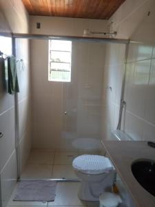 ein Badezimmer mit Dusche, Toilette und Waschbecken in der Unterkunft Casa dois andares com área de churrasco em Ibitipoca in Conceição da Ibitipoca + 63 Fotos