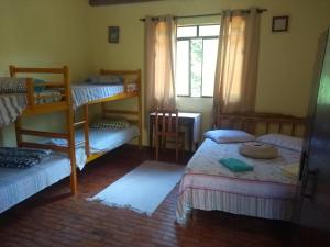 Zimmer mit 4 Etagenbetten und einem Fenster in der Unterkunft Casa dois andares com área de churrasco em Ibitipoca in Conceição da Ibitipoca