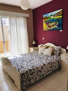 ein Schlafzimmer mit einem großen Bett und einem Gemälde an der Wand in der Unterkunft Beautiful Apartment near the Sea in Paphos City