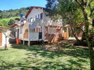 a white house with a tree in the yard at Casas do Adriano in Conceição da Ibitipoca