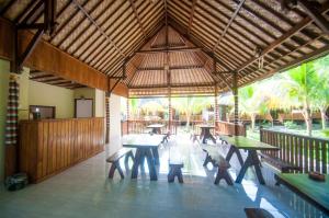 - un pavillon avec des tables et des bancs dans un patio dans l'établissement Ruji Ananta Cottage, à Nusa Penida