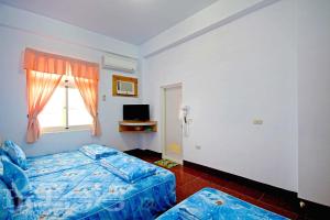 綠島鄉的住宿－綠島長泰民宿，一间卧室设有蓝色的床和窗户。