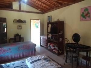 a living room with a bed and a table at Casas do Adriano in Conceição da Ibitipoca