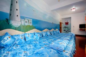 綠島鄉的住宿－綠島長泰民宿，卧室配有蓝色的床,墙上绘有灯塔