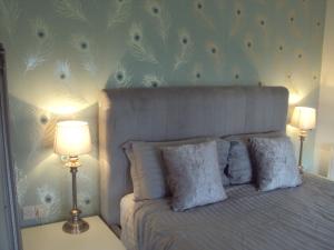 a bedroom with a bed with two lamps and flowers on the wall at Shannonside Studios in Athlone