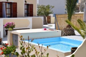 een zwembad in het midden van een tuin met een hot tub bij Marina's Studios in Perivolos