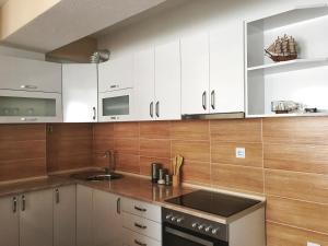 a kitchen with white cabinets and a sink at Vidojevski's Apartment in Ohrid