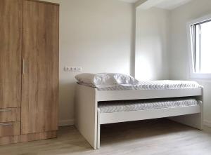 エリソンドにあるApartamento Turistico MJLのベッドルーム1室(ベッド1台付)、木製キャビネットが備わります。