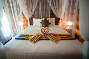 a bedroom with a bed with two towels on it at Ruji Ananta Cottage in Nusa Penida